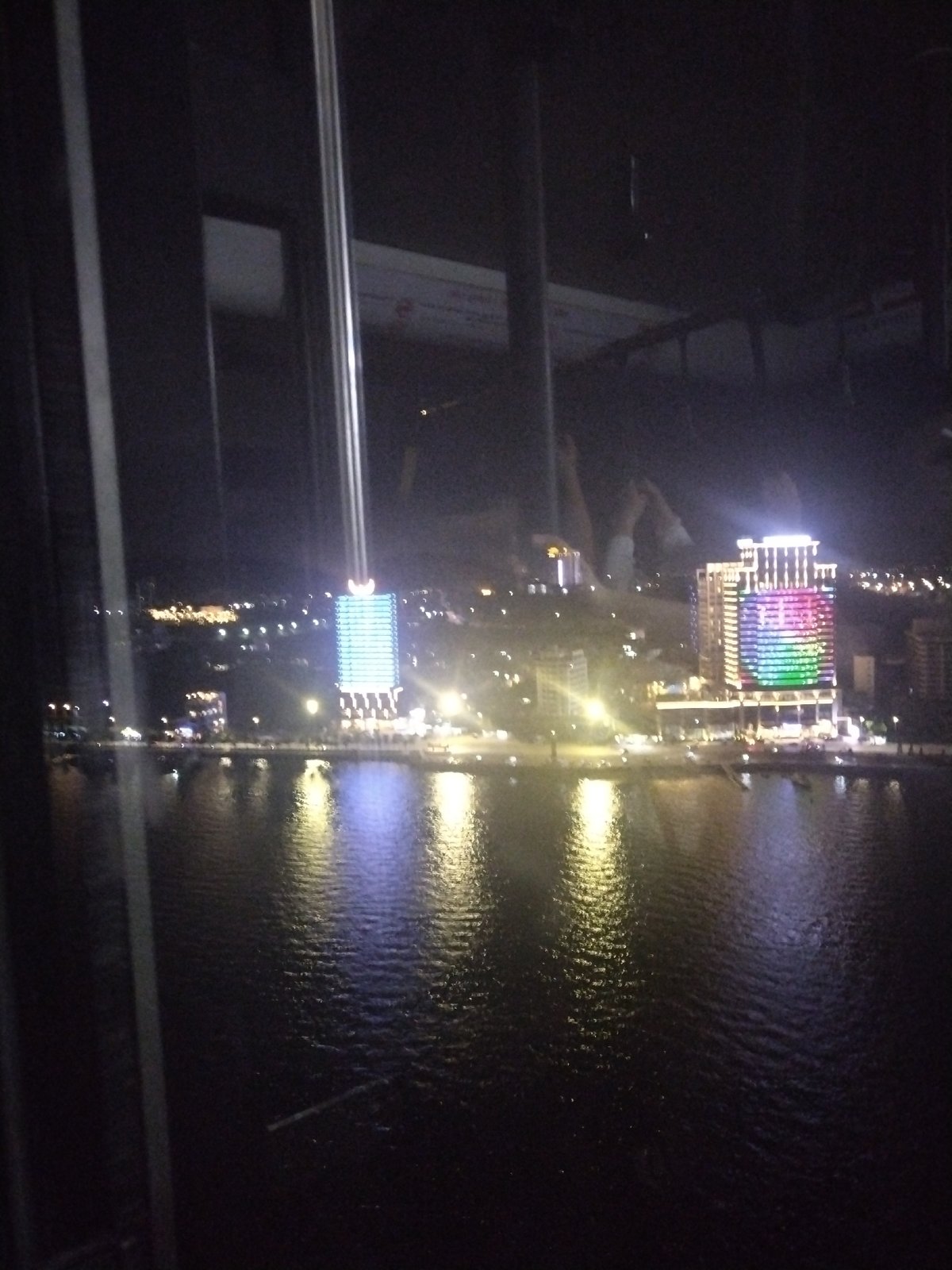 Nighttime cityscape reflection captured through window at undisclosed location
