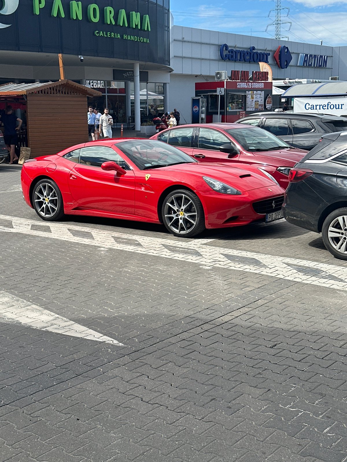 Red Ferrari parked outside Poznań's Panorama shopping center