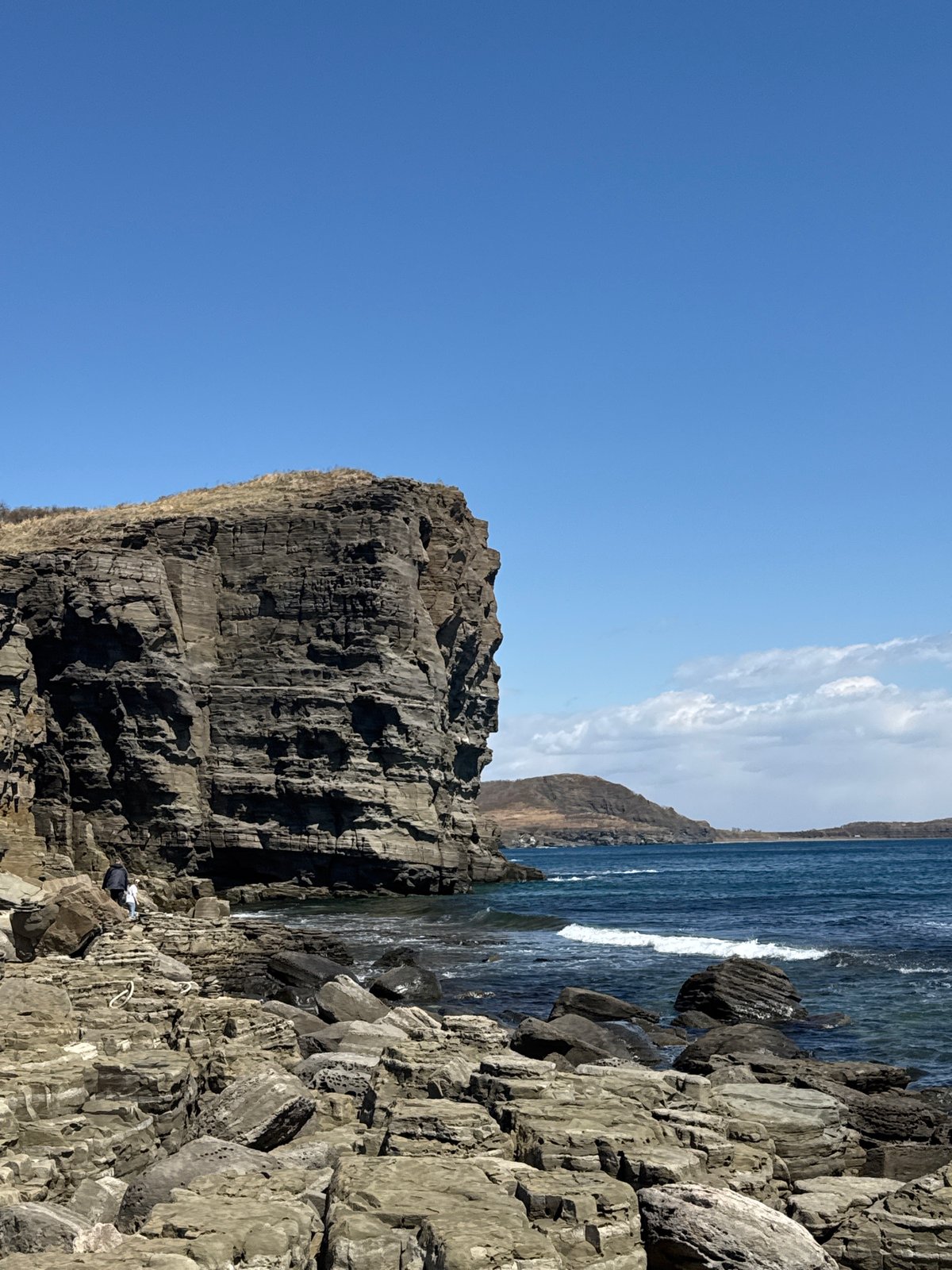Clear skies frame dramatic coastal cliffs at Russky Island