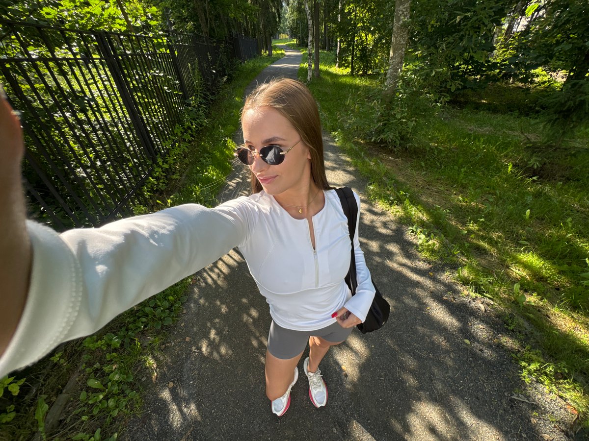 Casual walk through a park, selfie in hand.