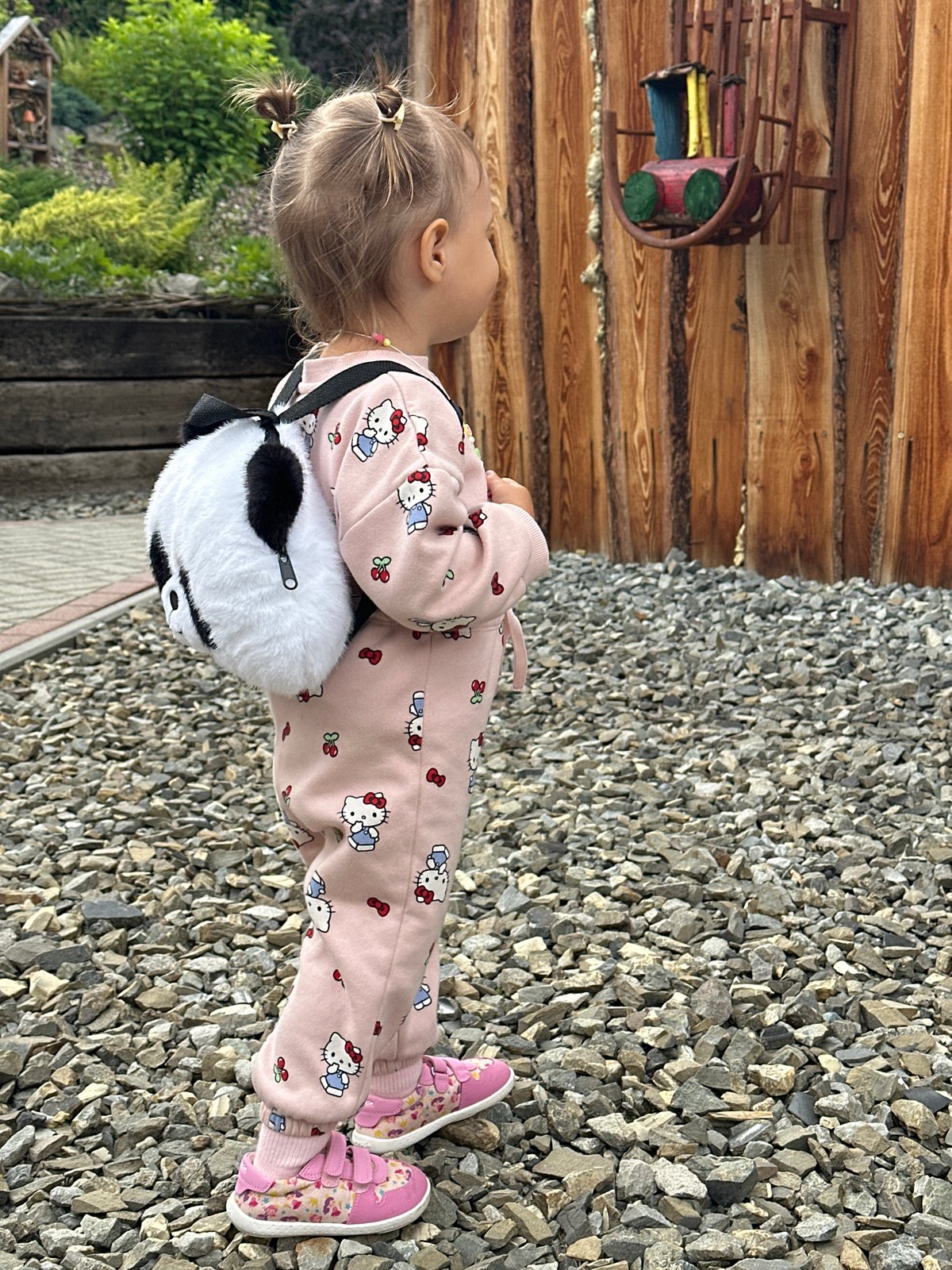 Kid in Hello Kitty gear on a gravel surface in Wisła