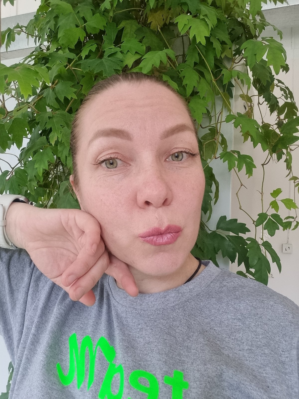 Woman takes indoor selfies near plant in Kemul, Russia
