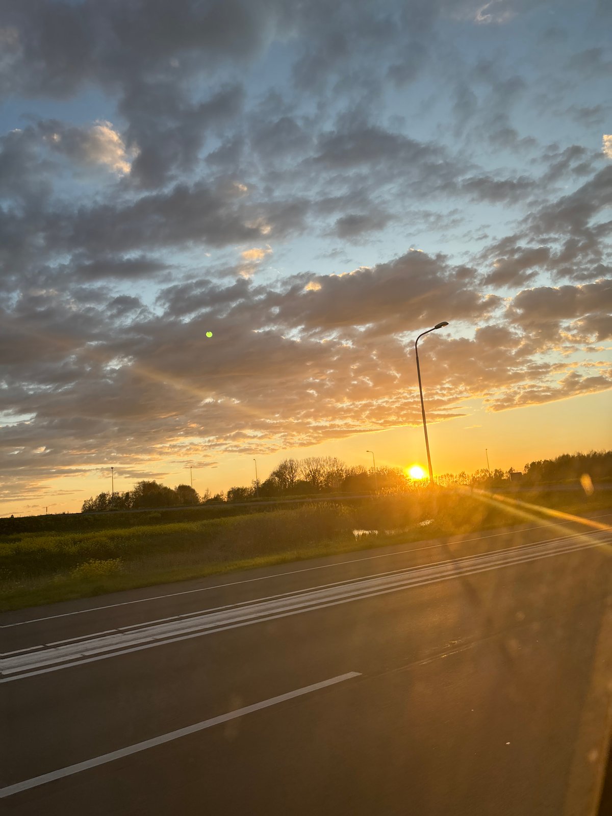 Highway sunset creates orange glow over Culemborg landscape