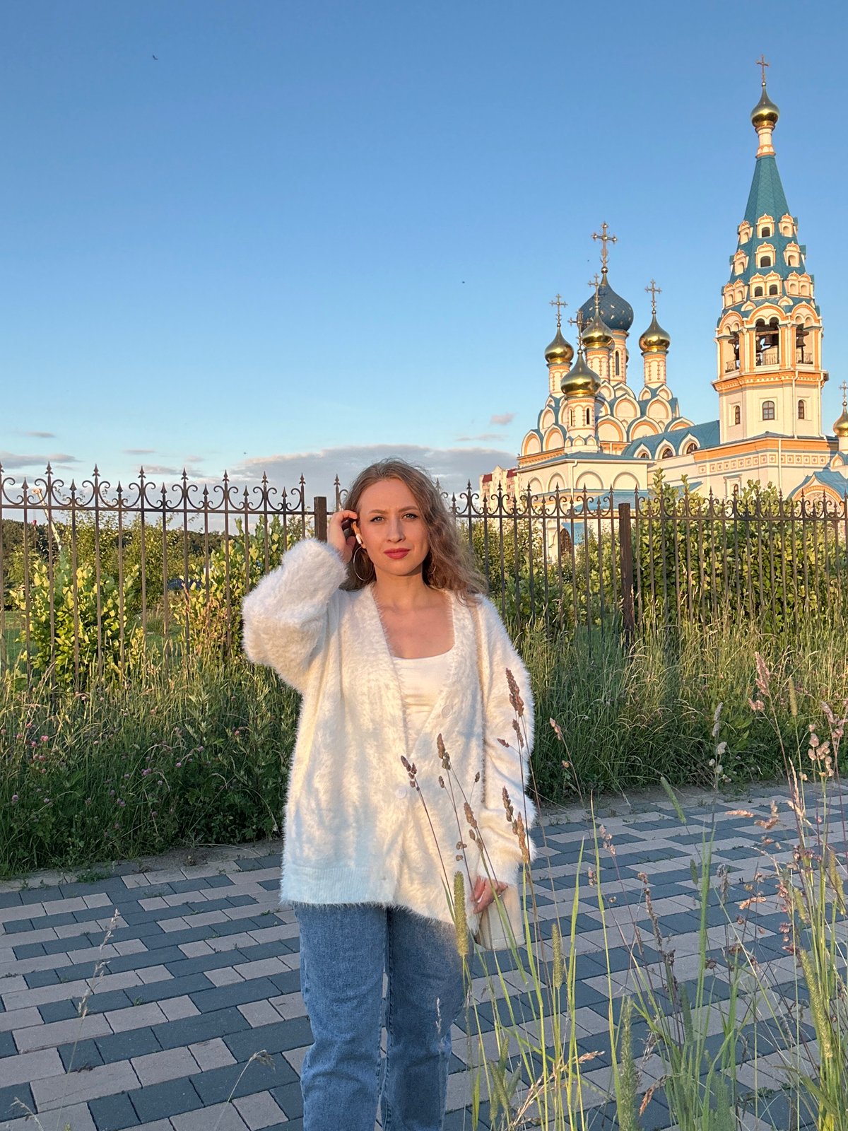 Casual moment on a Moscow walkway, hand raised to ear