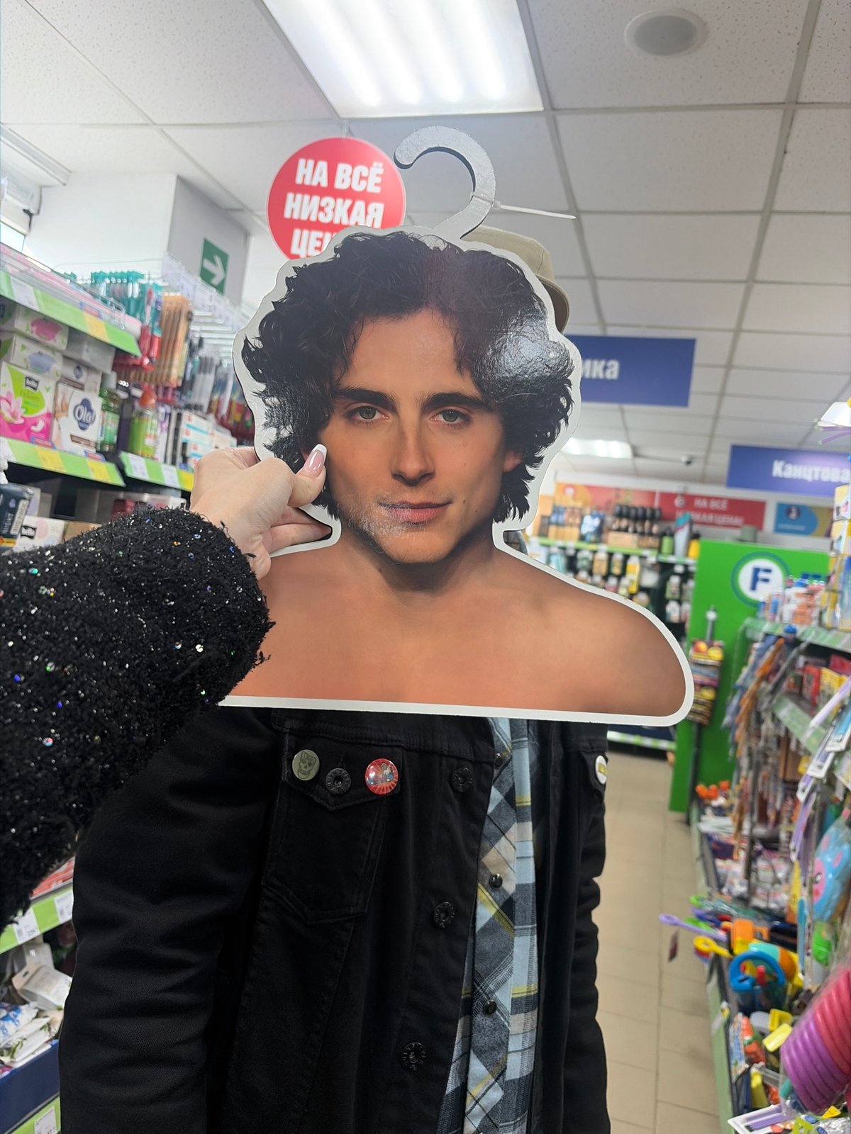Person holds male cardboard cutout in Saint Petersburg store