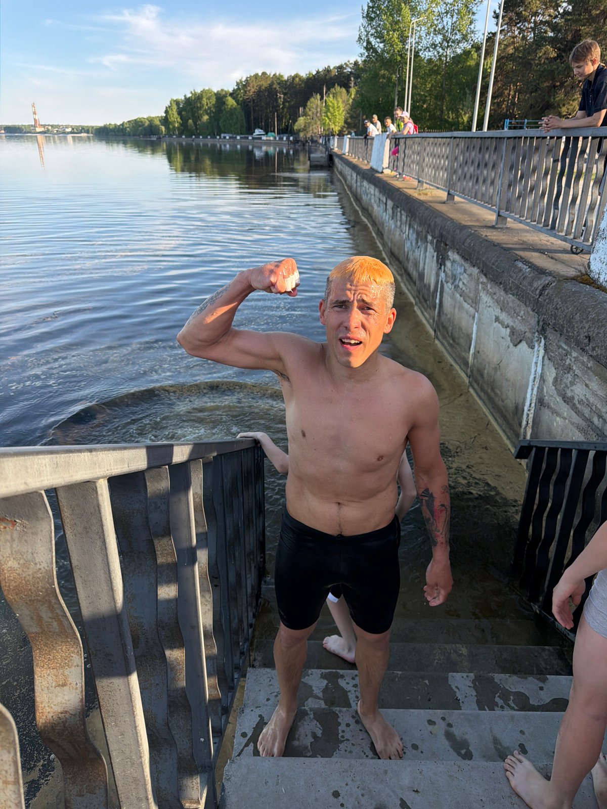 Man holds white object while swimming in Chaikovsky, Russia