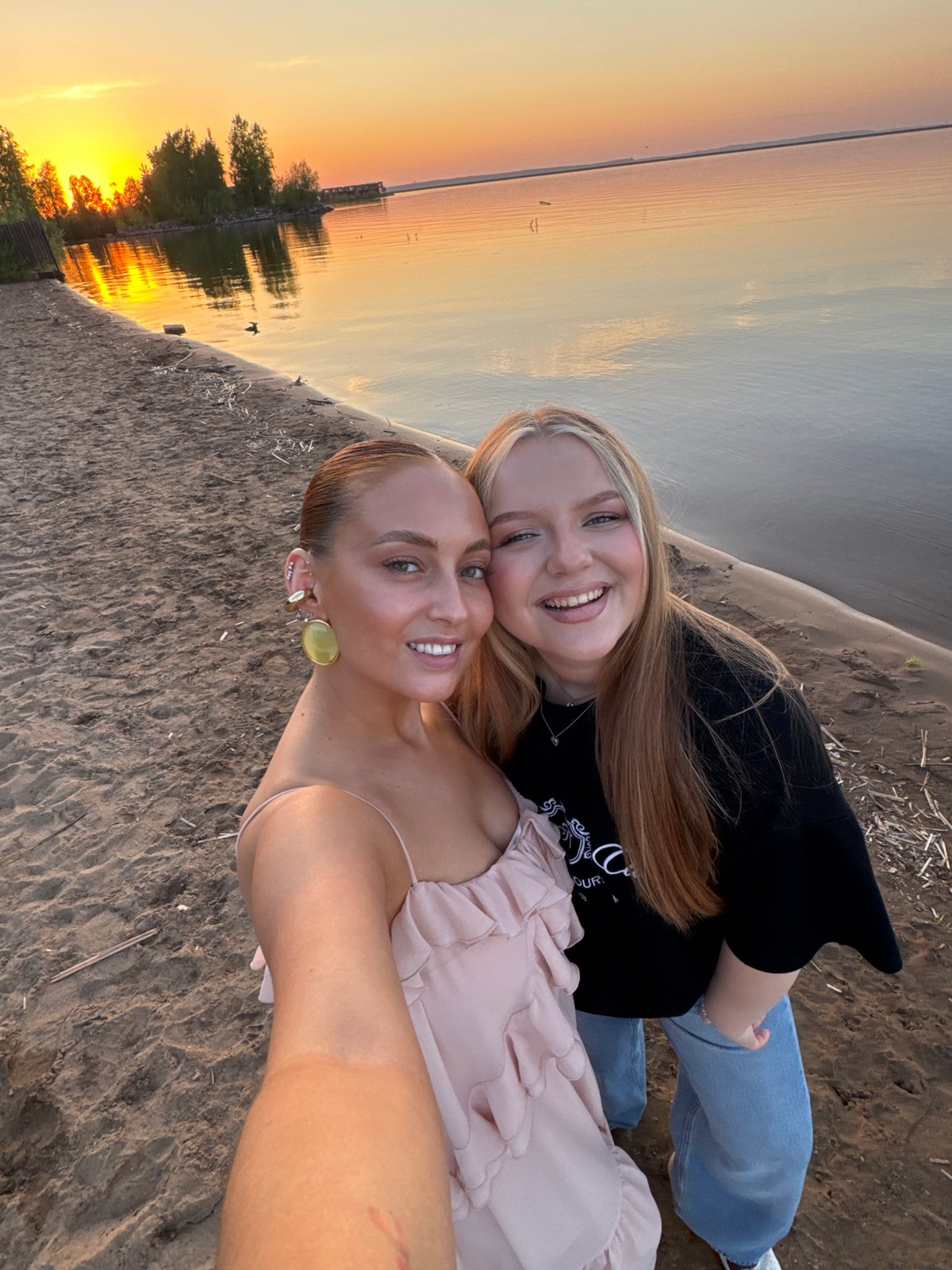 Two women take sunset selfies on Chaikovsky beach