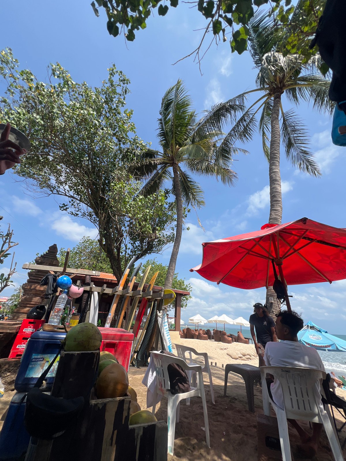 Surfers and beachgoers fill a lively morning at Kuta Beach