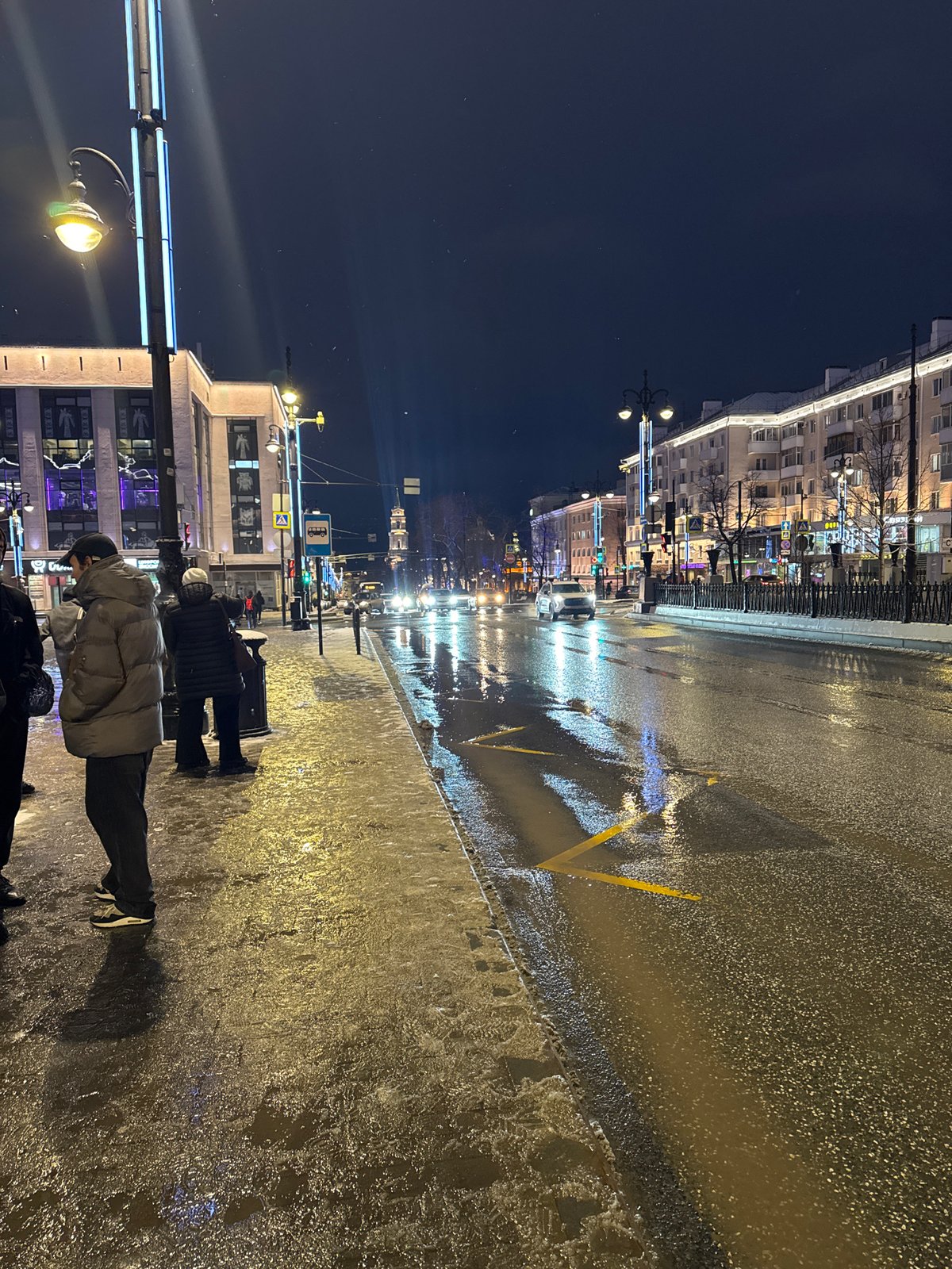 Wet street scene captured in nighttime Perm, Russia