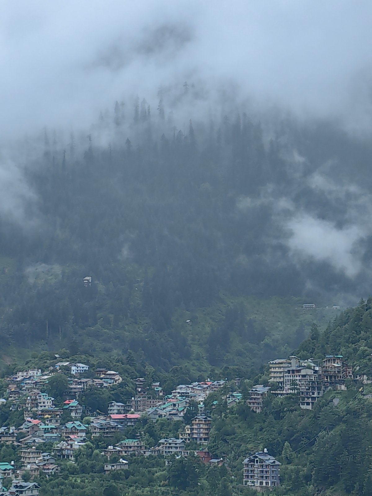 Misty morning in Vashisht, mountains fogged in, village life continuing