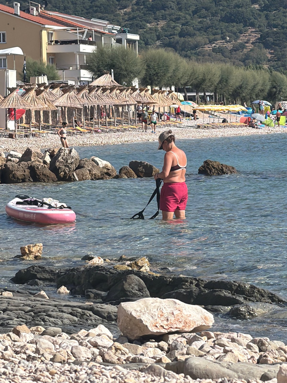 Summer morning at Baška's rocky beach, dogs and pedal boats included