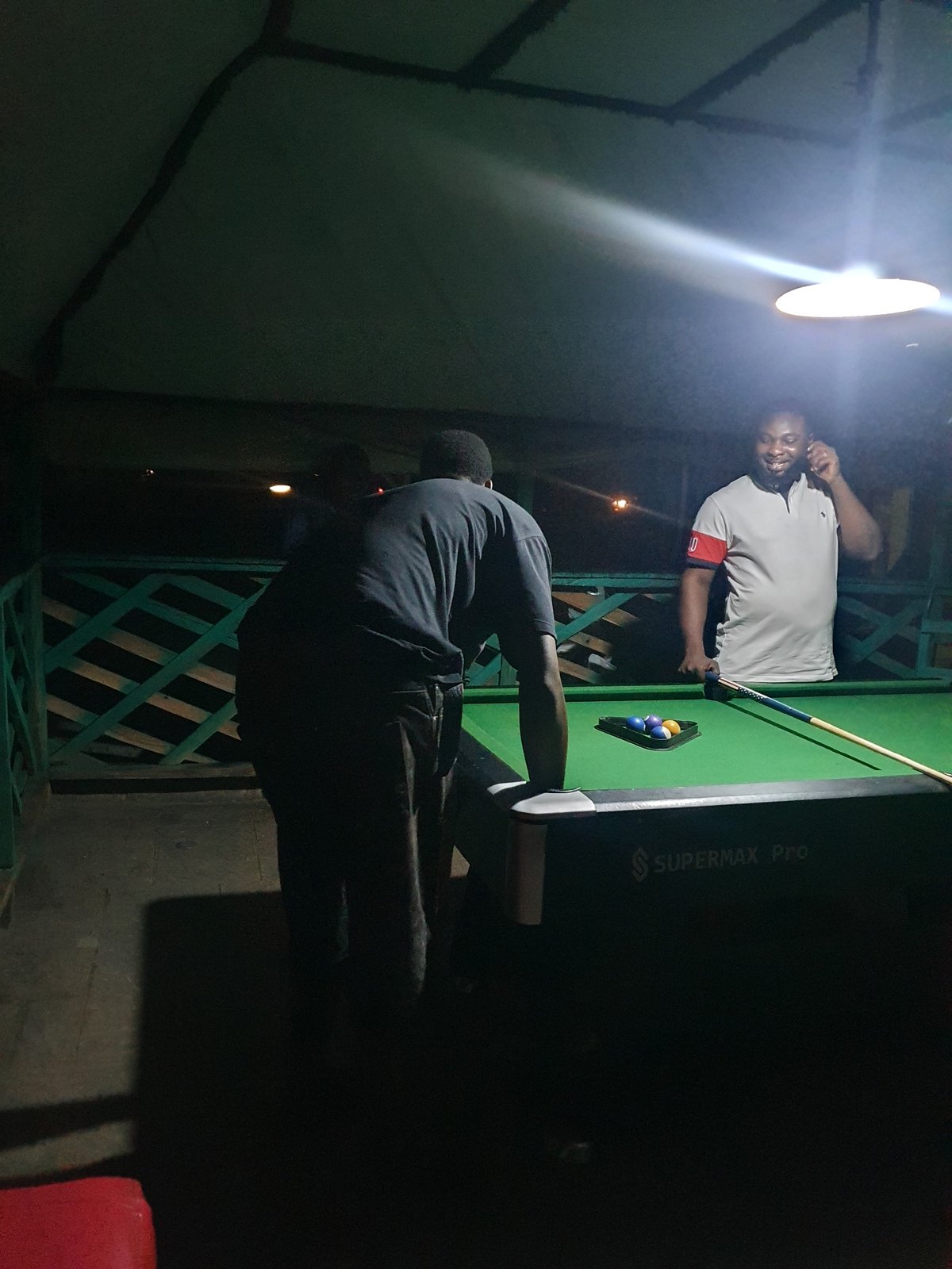 Men play evening pool at outdoor venue in Lokoja