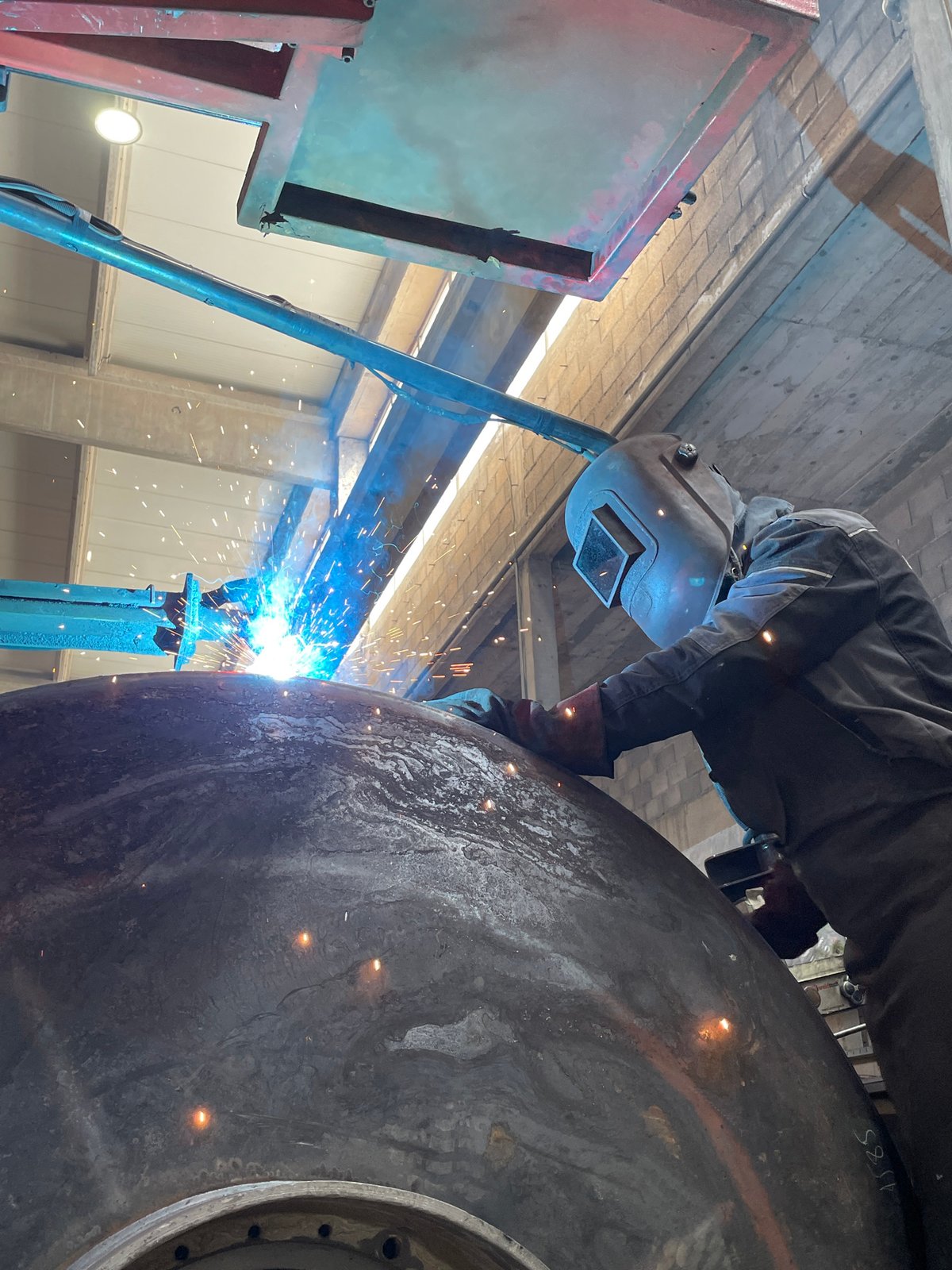 Welder works on metal object in Čeluga workshop