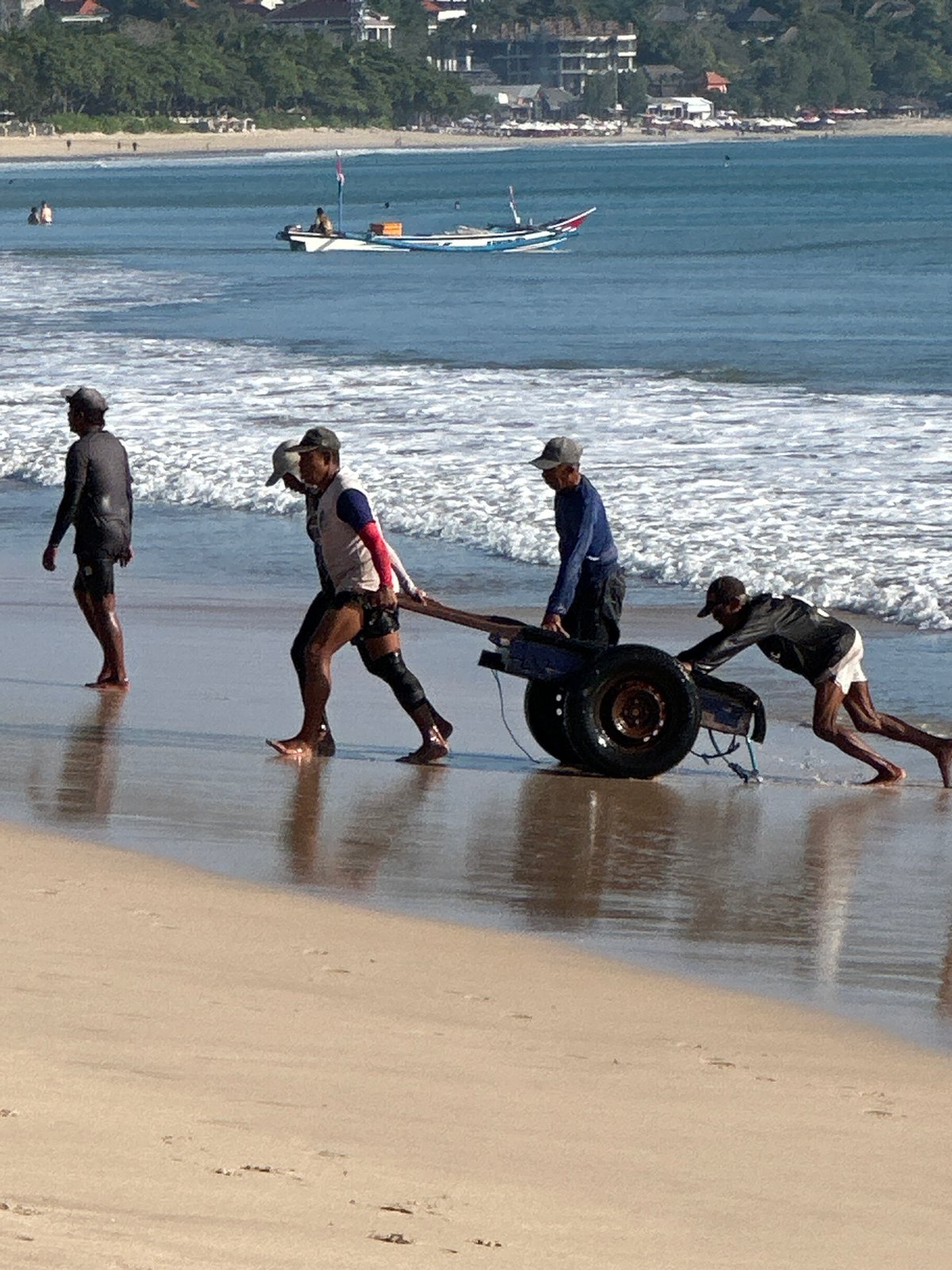 Fishing boats, open water, and a beach ceremony in Kuta