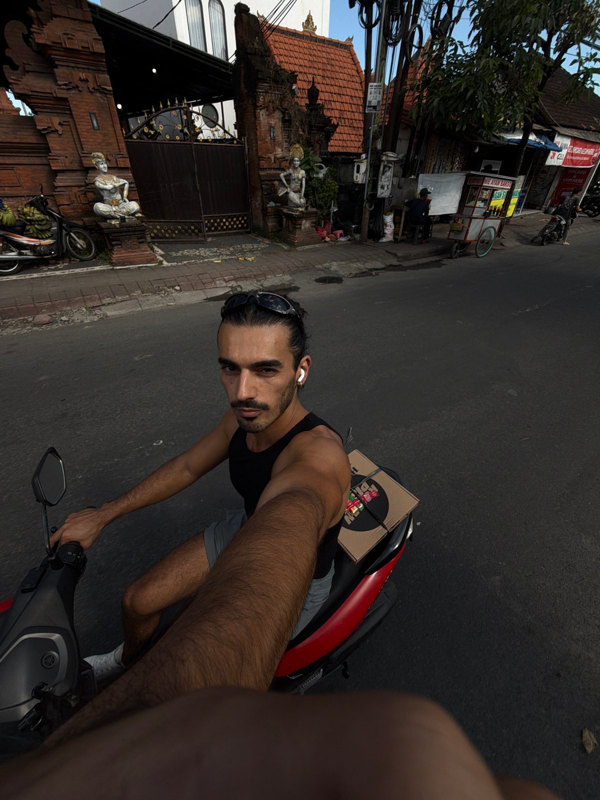 Scooter rider captures selfies during morning ride in North Kuta