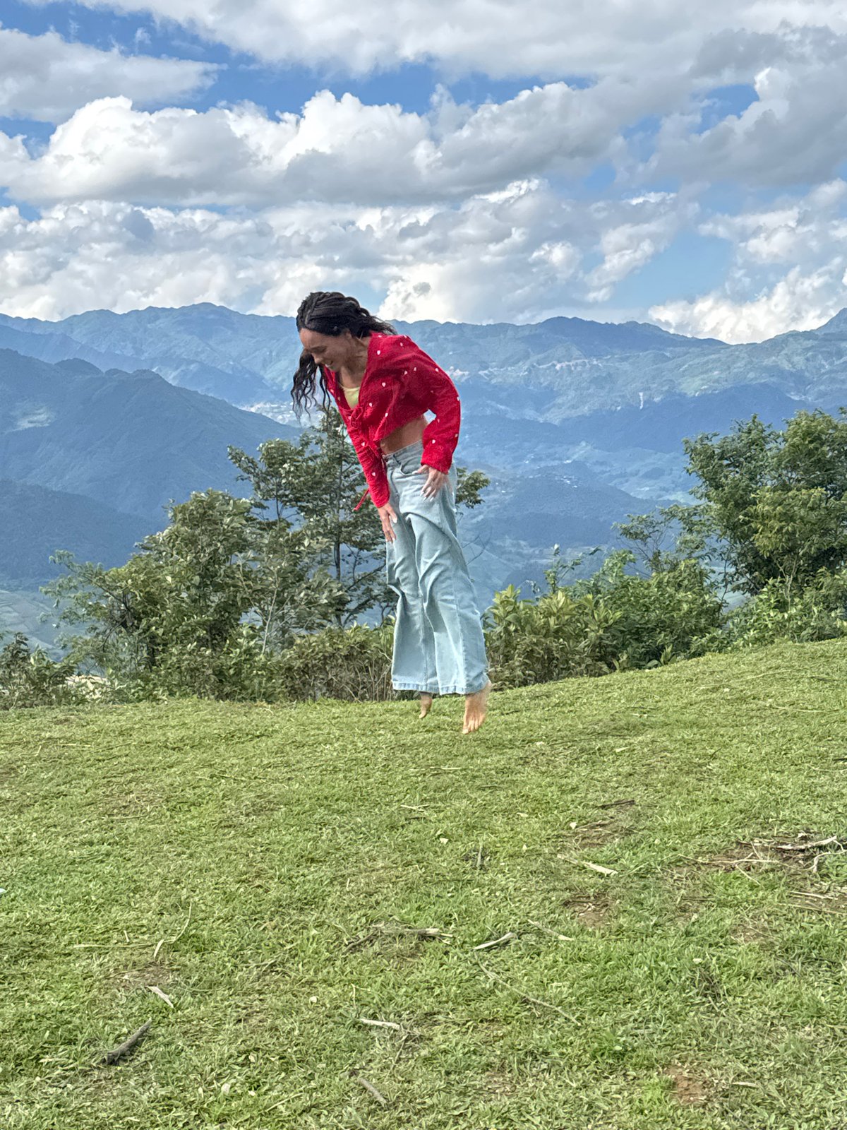 Tourists jump and pose on Tu Le hilltop during morning visit