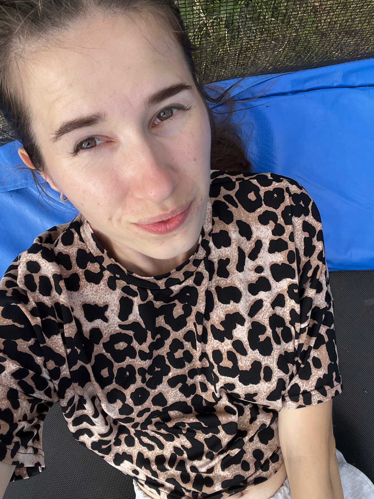 Kids and an adult hang out on a backyard trampoline