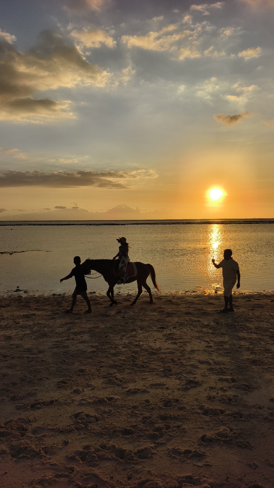 Beach horseback riding captured at Indonesian coastal tourist destination