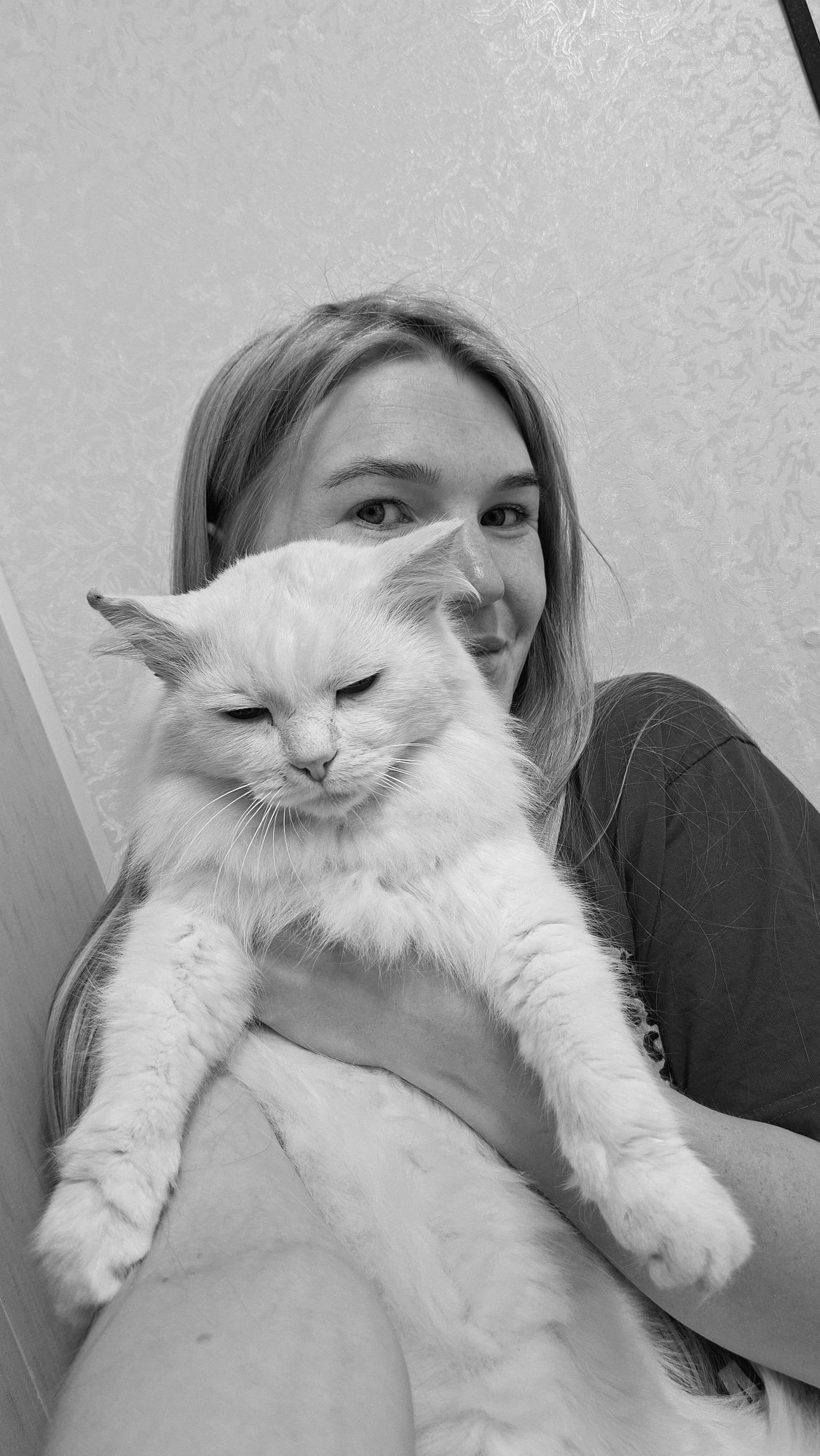 Woman photographs herself with white cat in Russian village