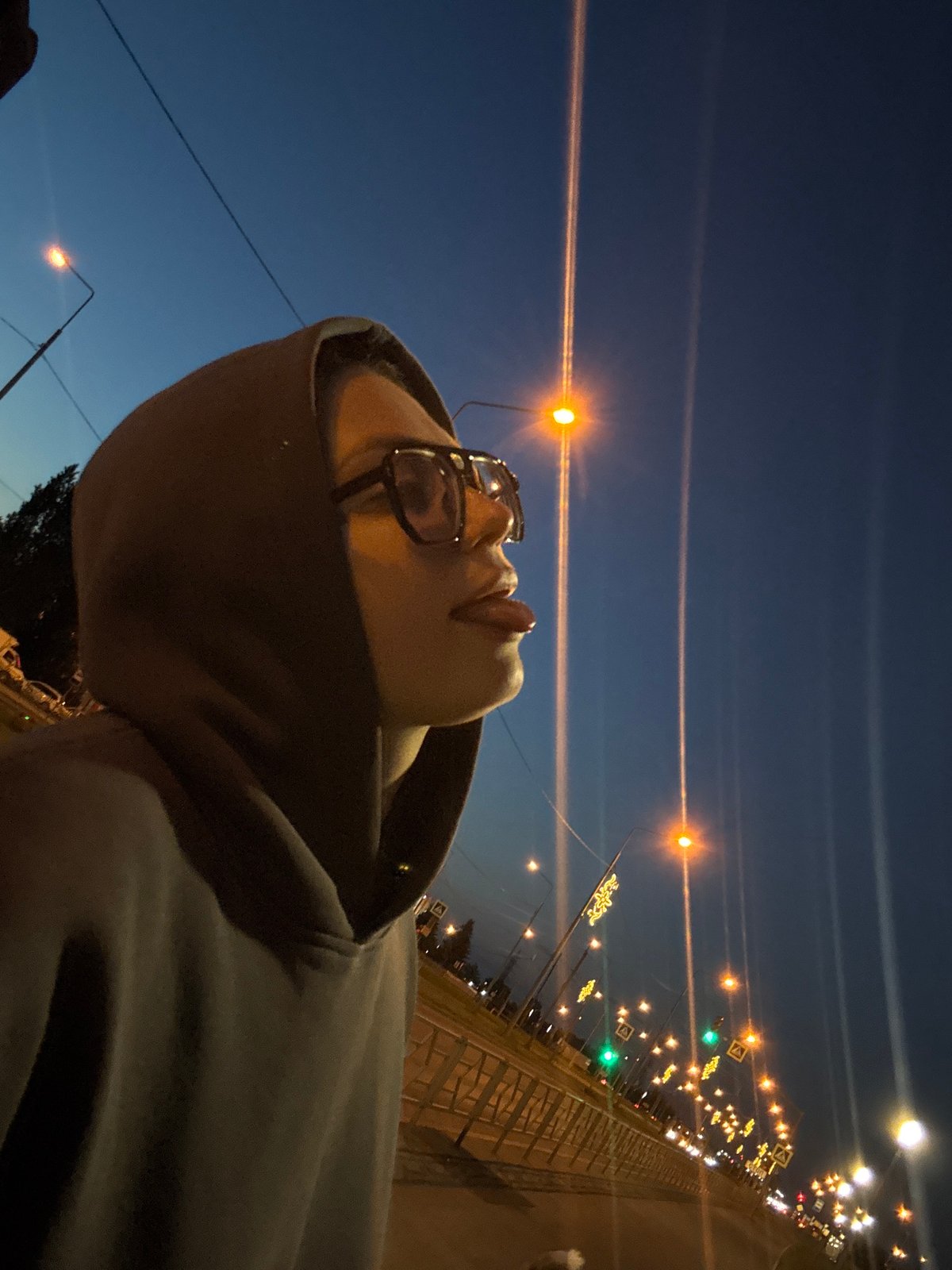 Hooded figure photographed repeatedly during urban twilight walk