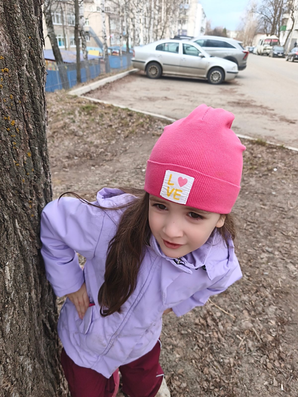 Child plays outdoors in urban setting during afternoon outing