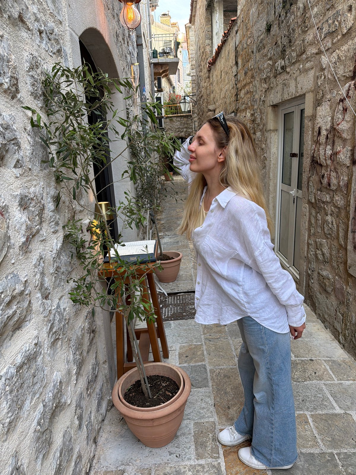Woman poses for photos in historic Budva alleyway