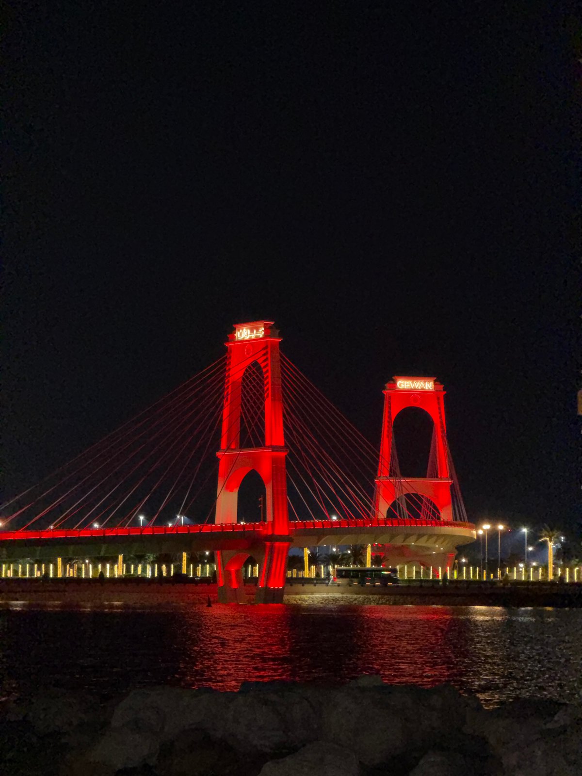 Glowing skyline, red suspension bridge, full moon over the waterfront