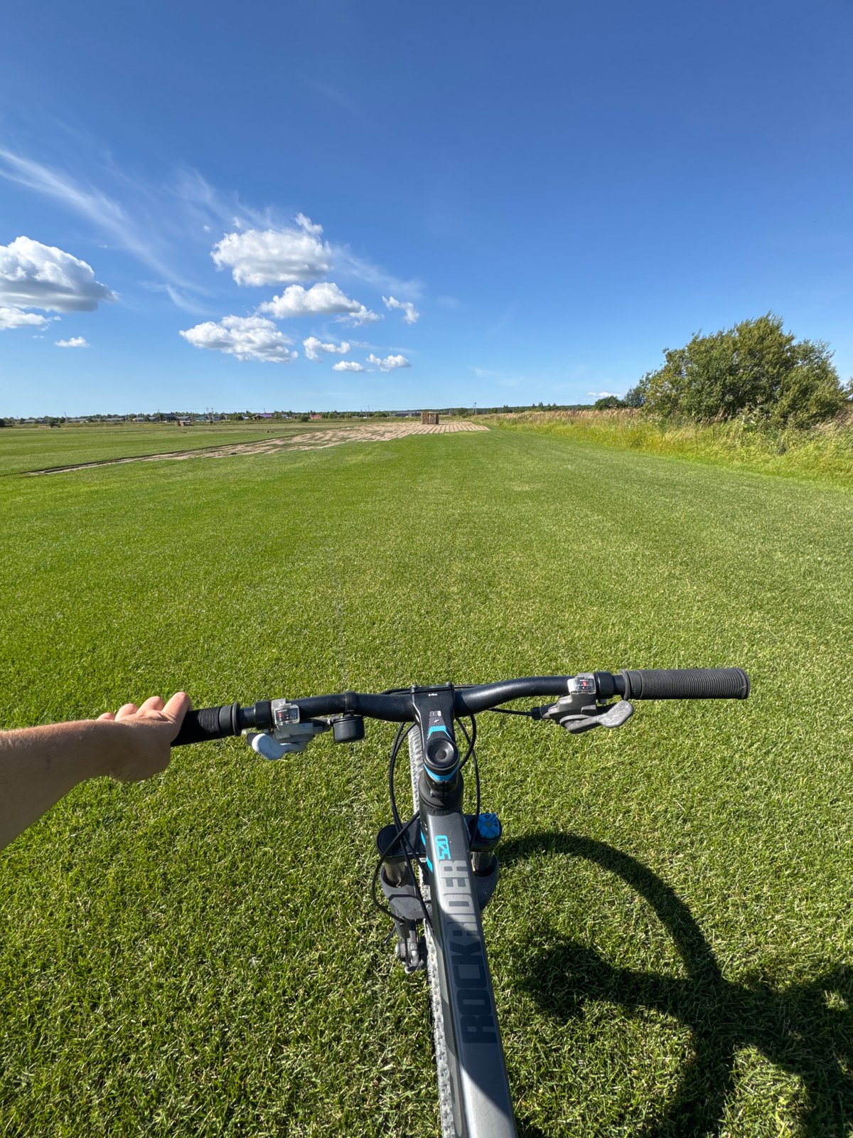 Sunny afternoon bike ride across a green field in Kempelevo