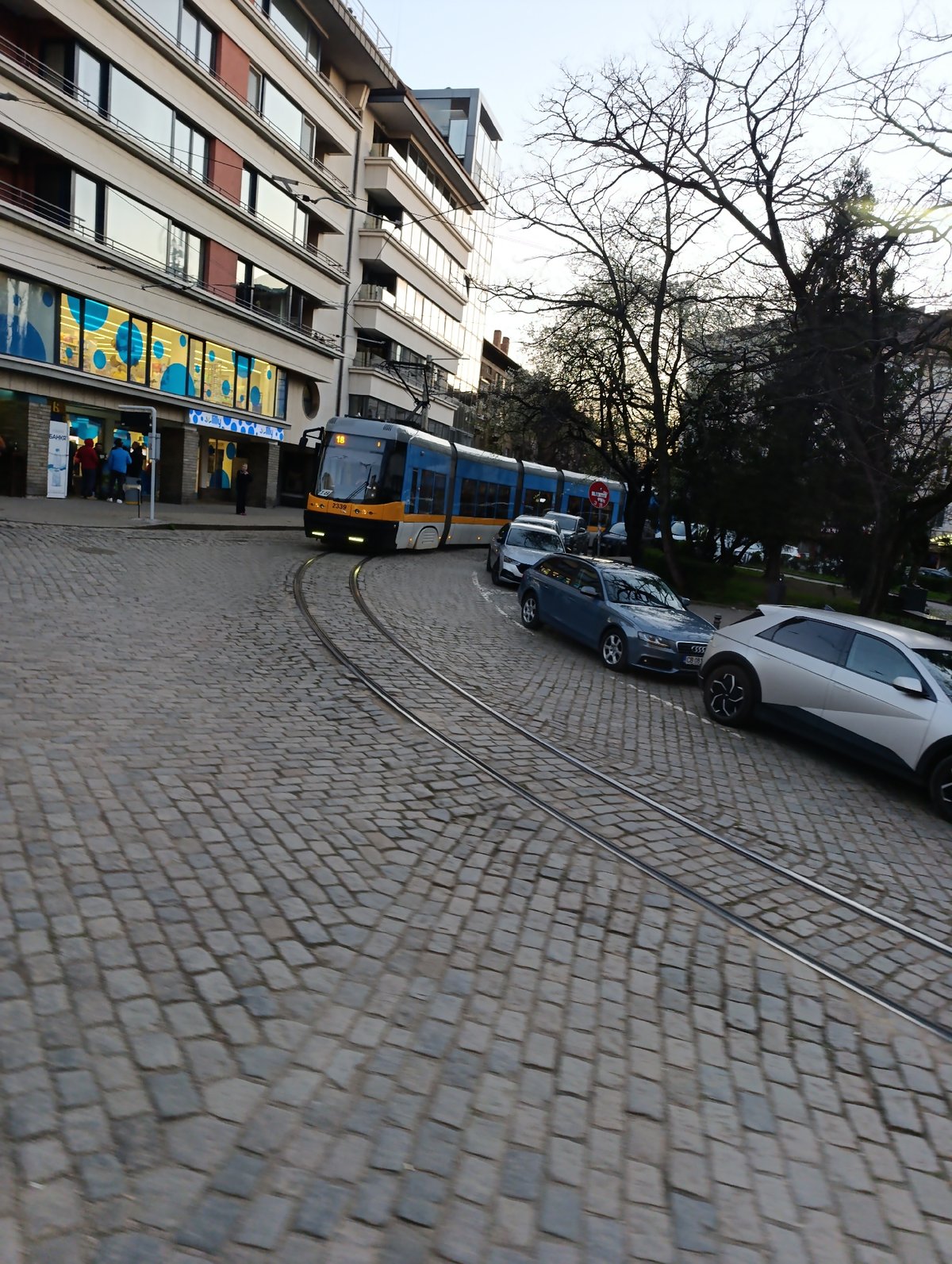 Tram navigates cobblestone street in historic Sofia district