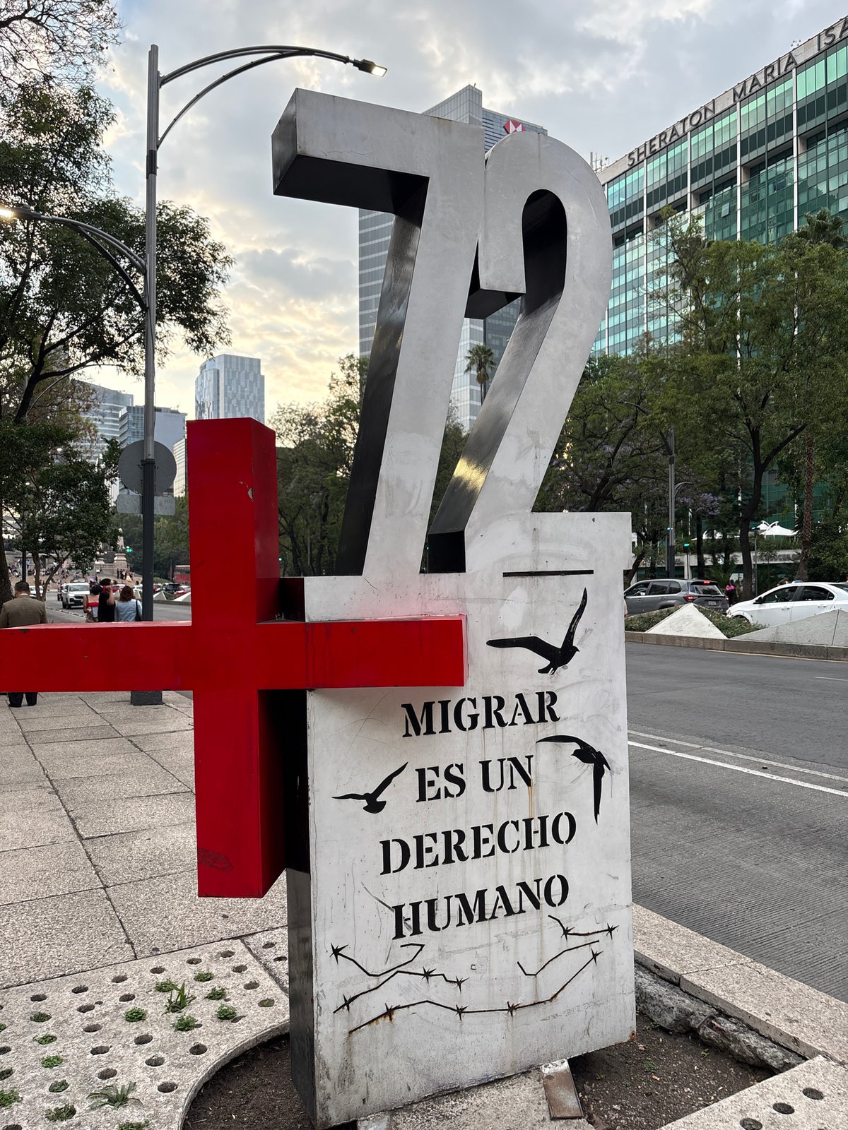Migrant memorial monument with metallic "72" sculpture documented in Mexico City