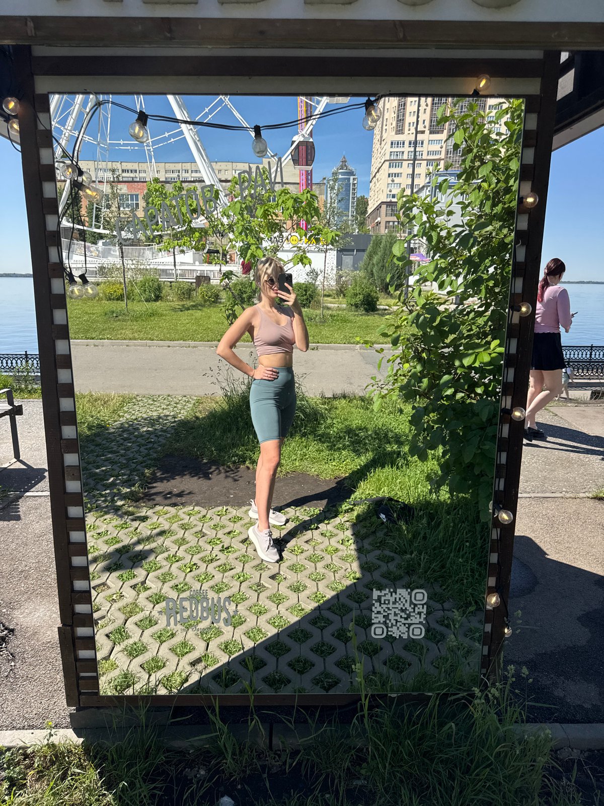Woman takes morning selfies at mirrored Saratov embankment installation