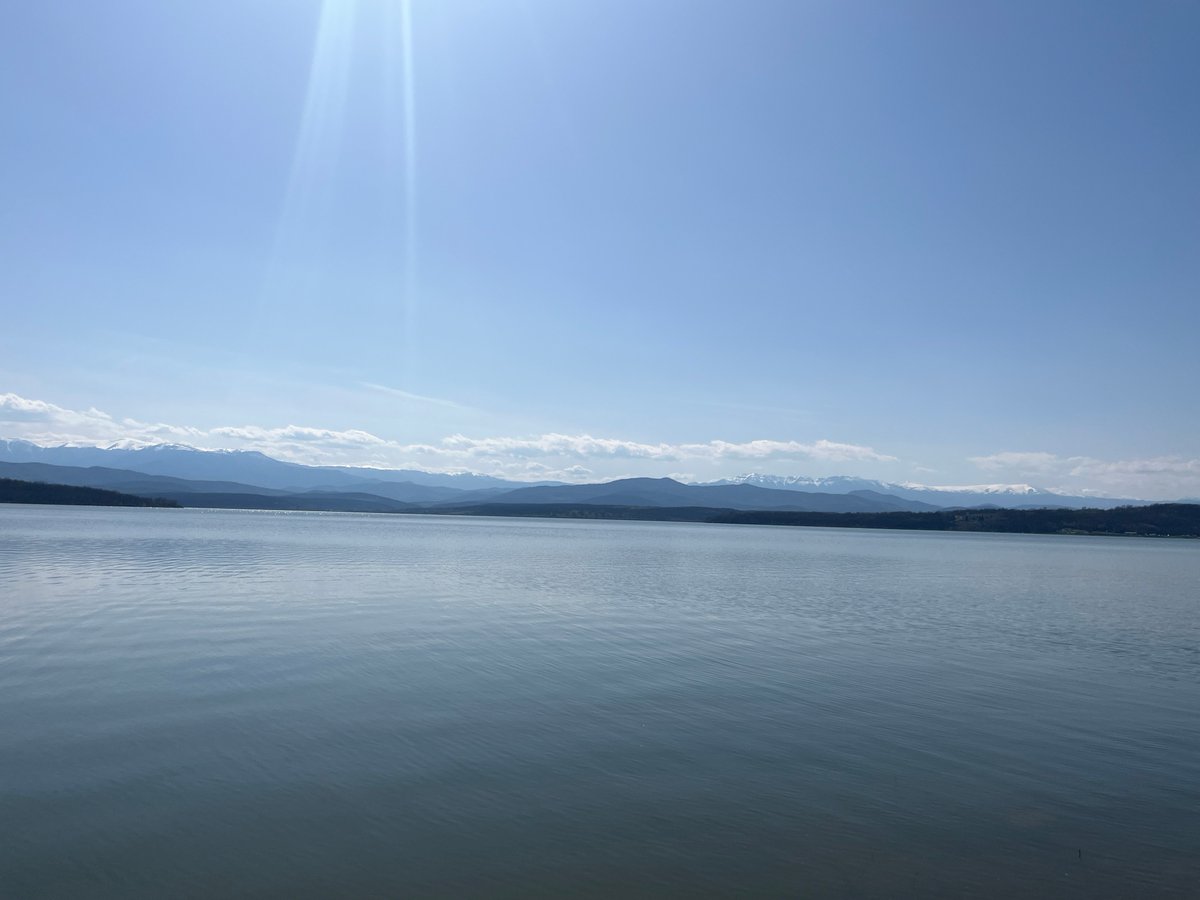Young person kneels by lake in Montana, Bulgaria