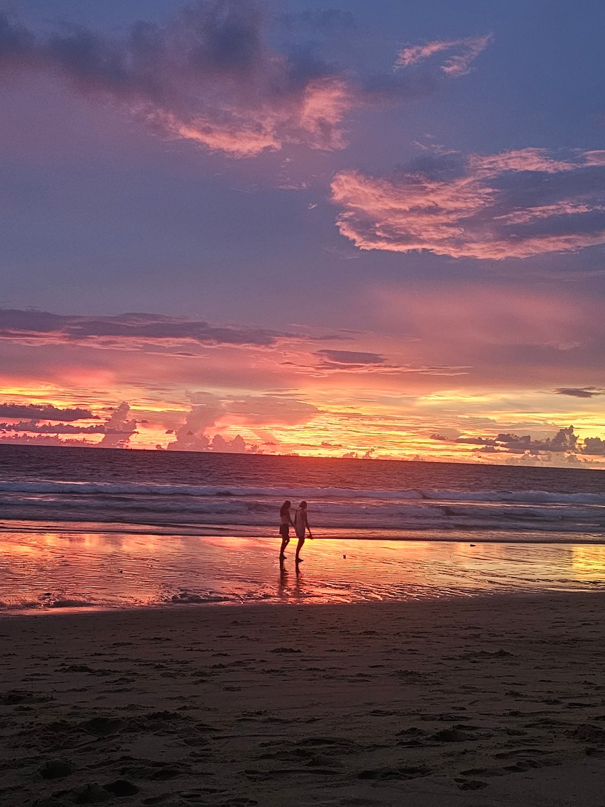 Beach sunset in Sakhu, Thailand, with people unwinding at dusk