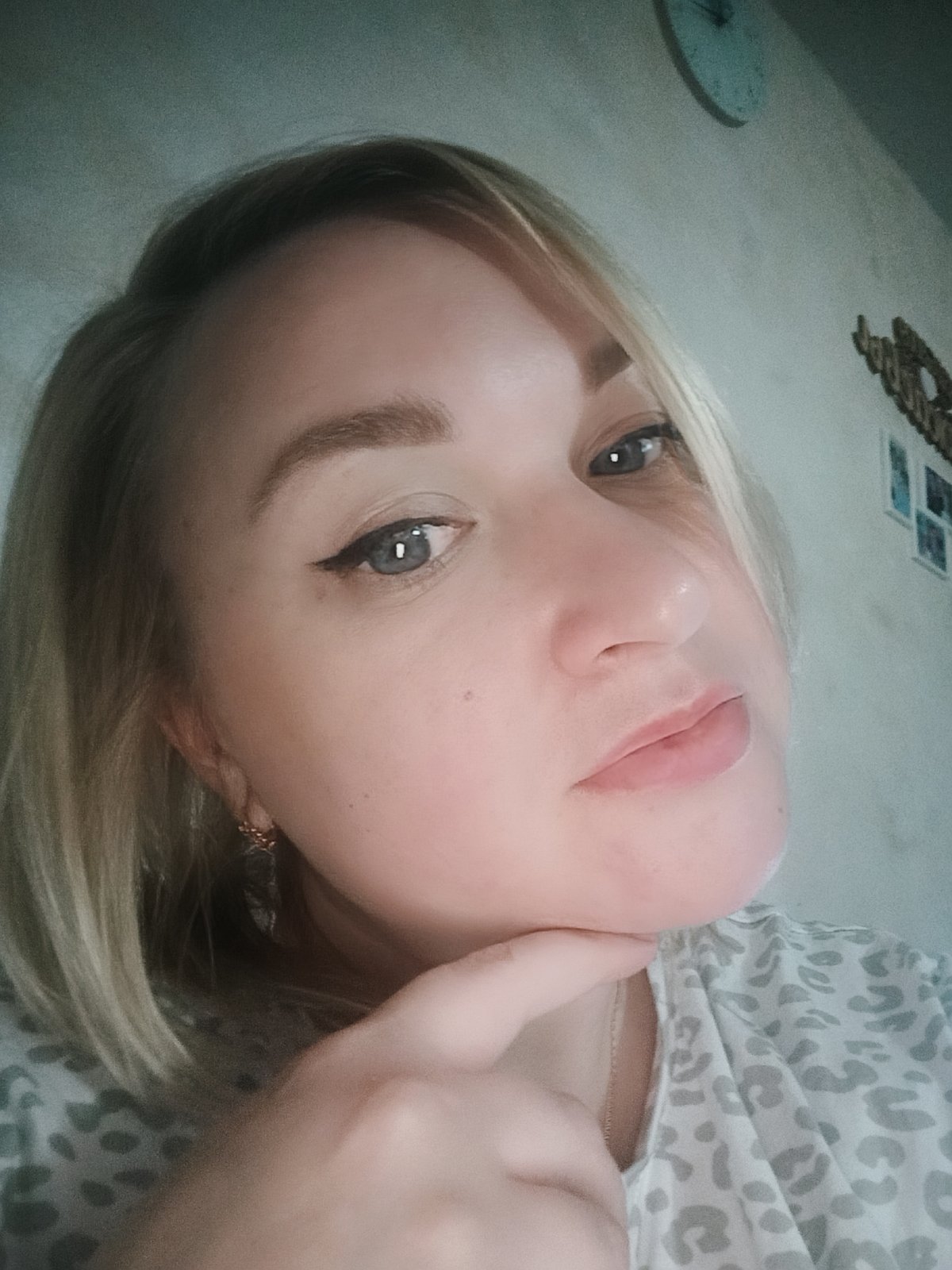 Blonde woman poses for multiple selfie shots indoors