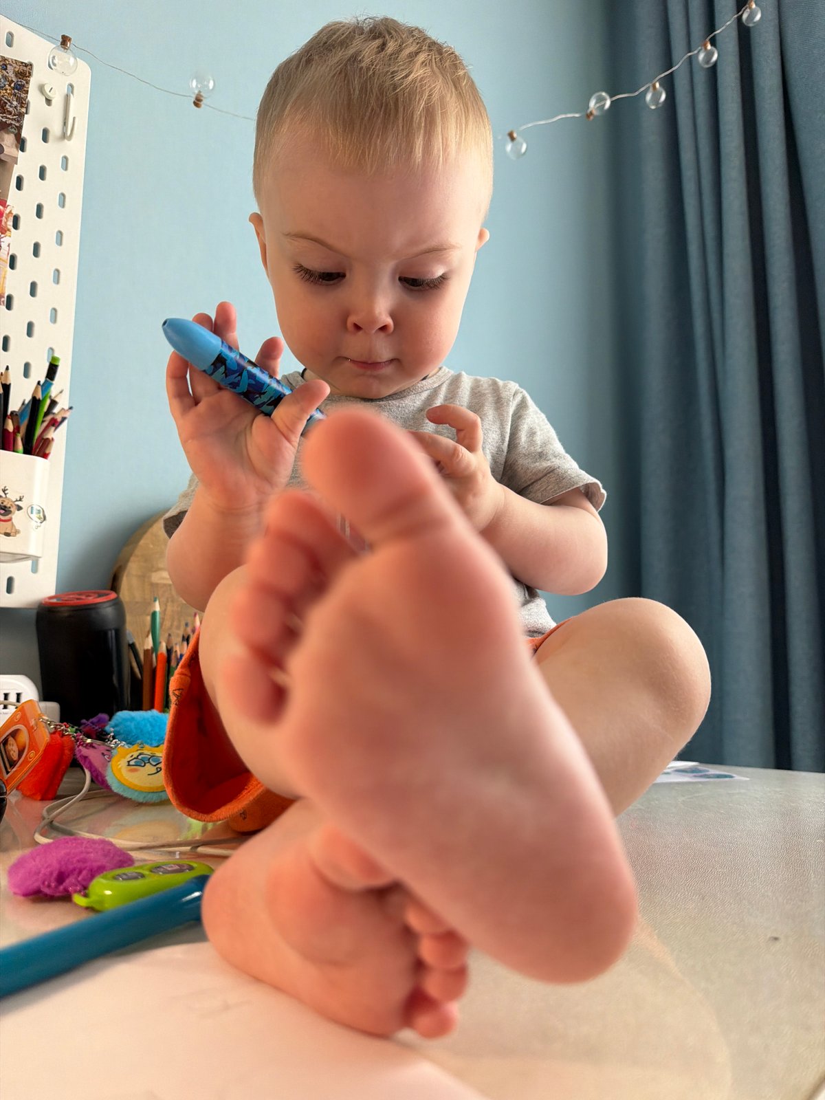 Toddler enjoys creative playtime with toys and drawing in Votkinsk