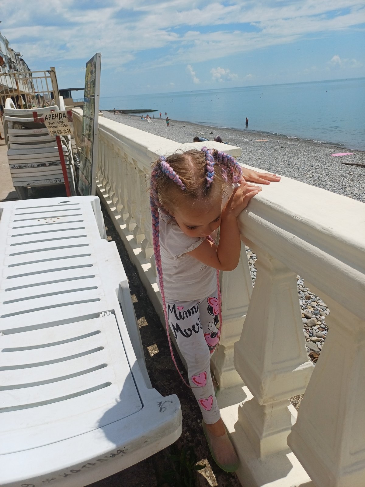 Children feed puppy on Sochi patio during summer morning