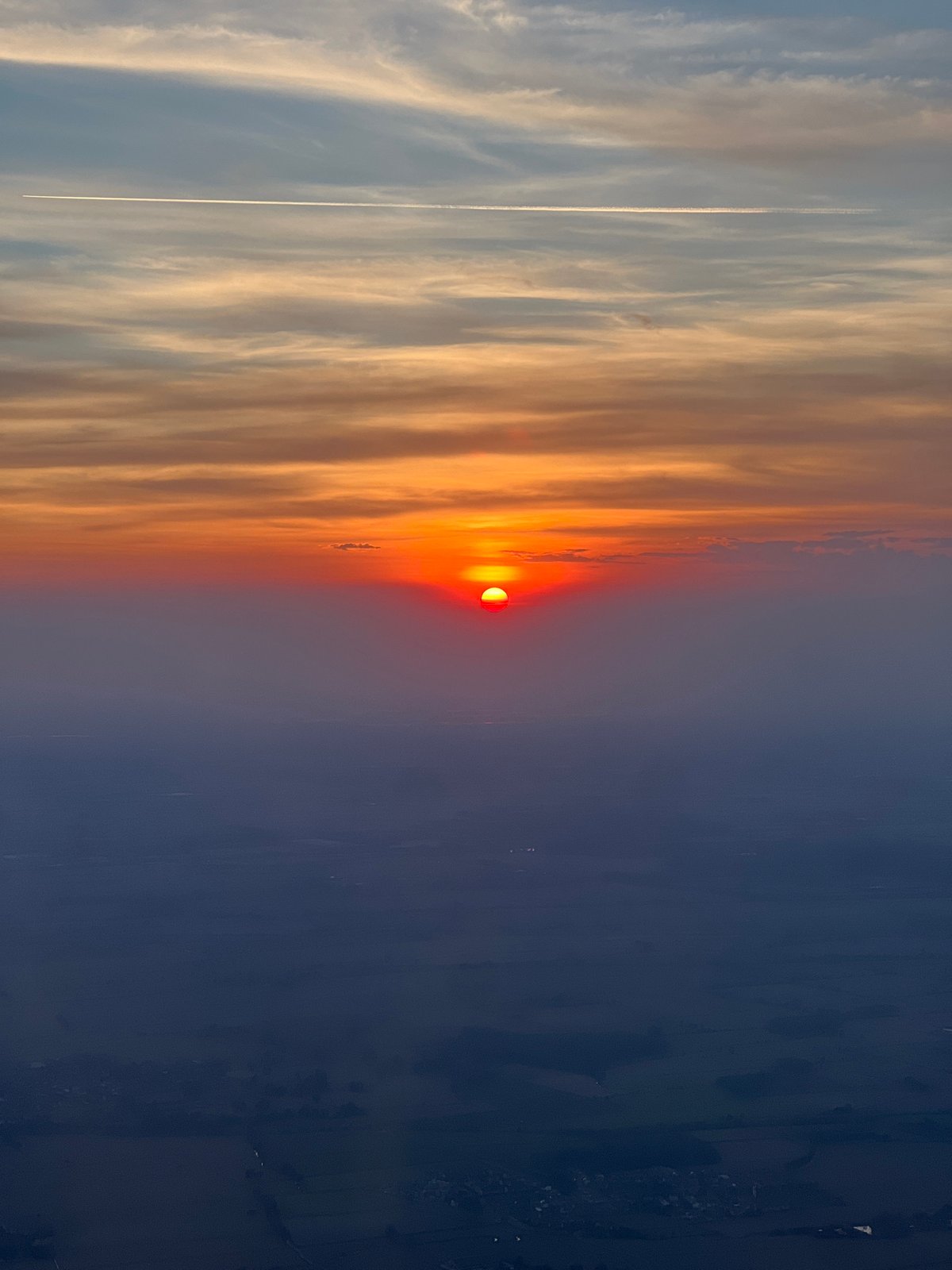 Vivid red sunset observed through orange clouds in Spirago, Italy