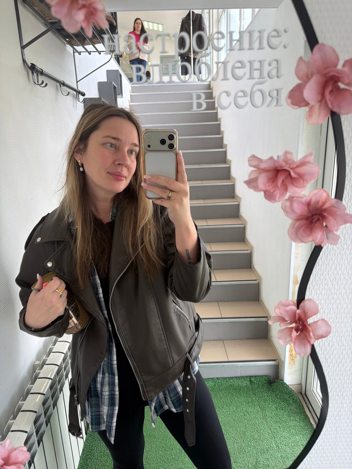 Woman takes mirror selfie amid flowers in Chaikovsky, Russia