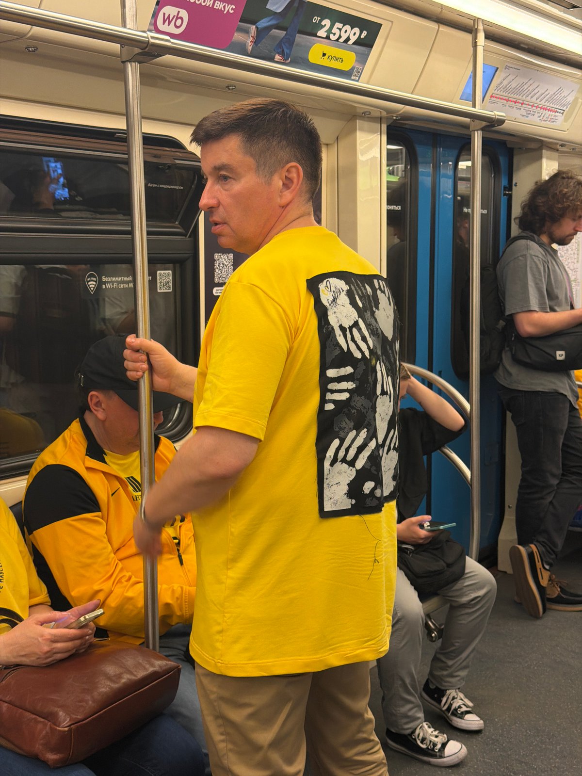Man in yellow shirt observed on crowded subway car