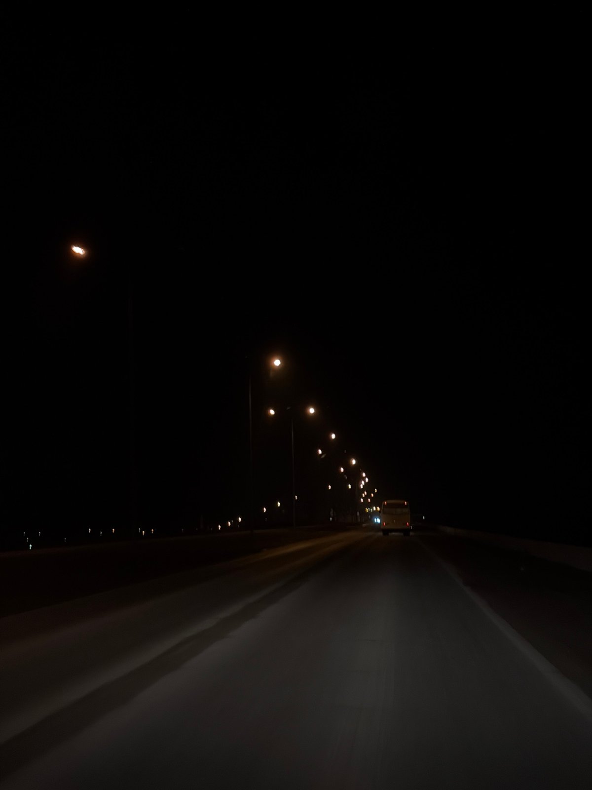Vehicle travels illuminated highway in Chaikovsky, Russia