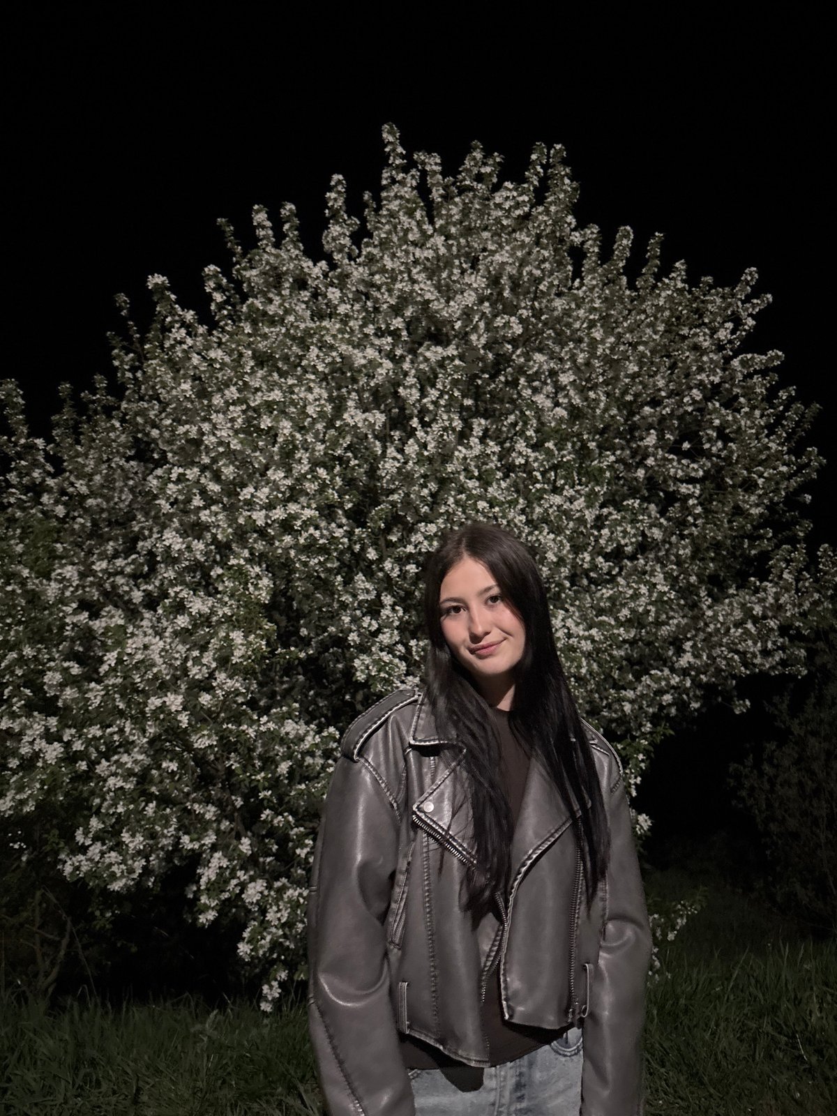 Woman observed near blossoming tree in Фоки park at night