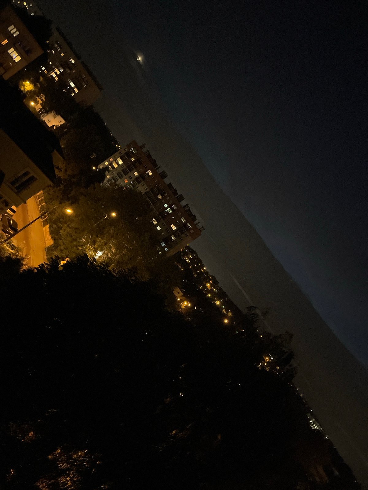 Evening in the city: crescent moon, apartment lights, rooftop vibes