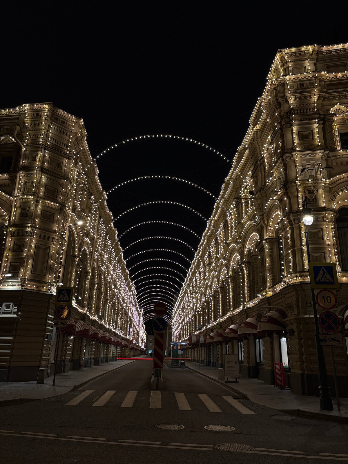 Nighttime street illuminated with extensive warm architectural lighting display