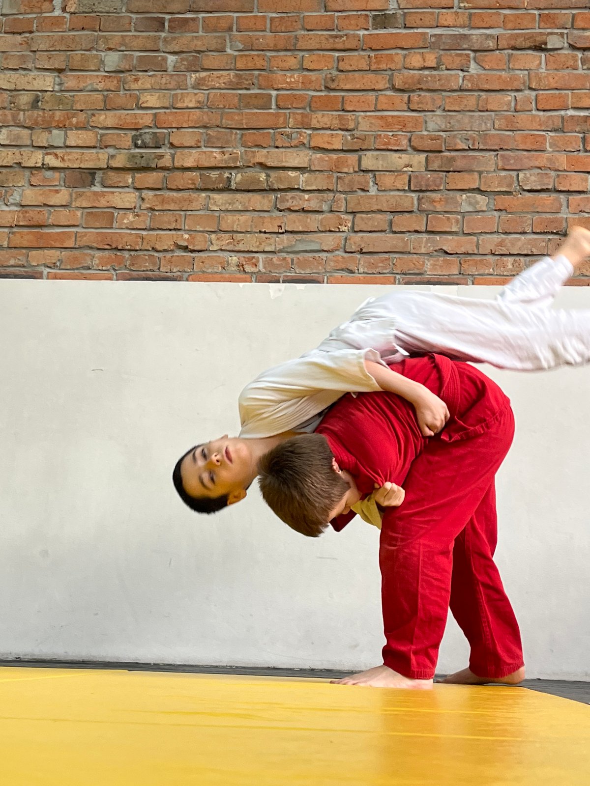 Young judoka practice grappling techniques in Krasnoyarsk training facility