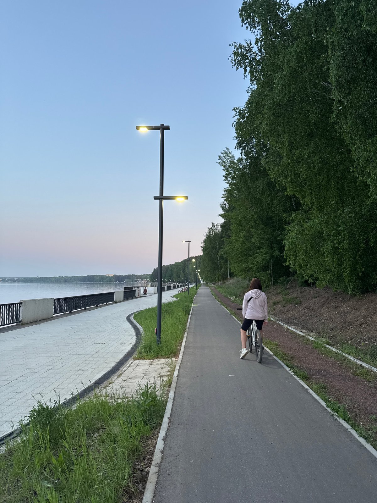 Cyclist spotted on riverside path in Chaikovsky, Russia