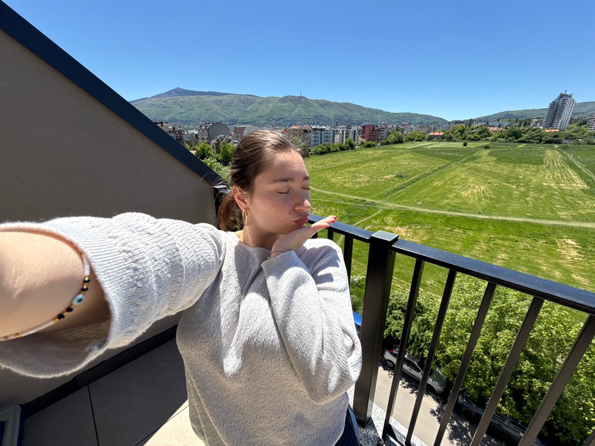 Person enjoys morning balcony time with Bulgarian snacks in Sofia