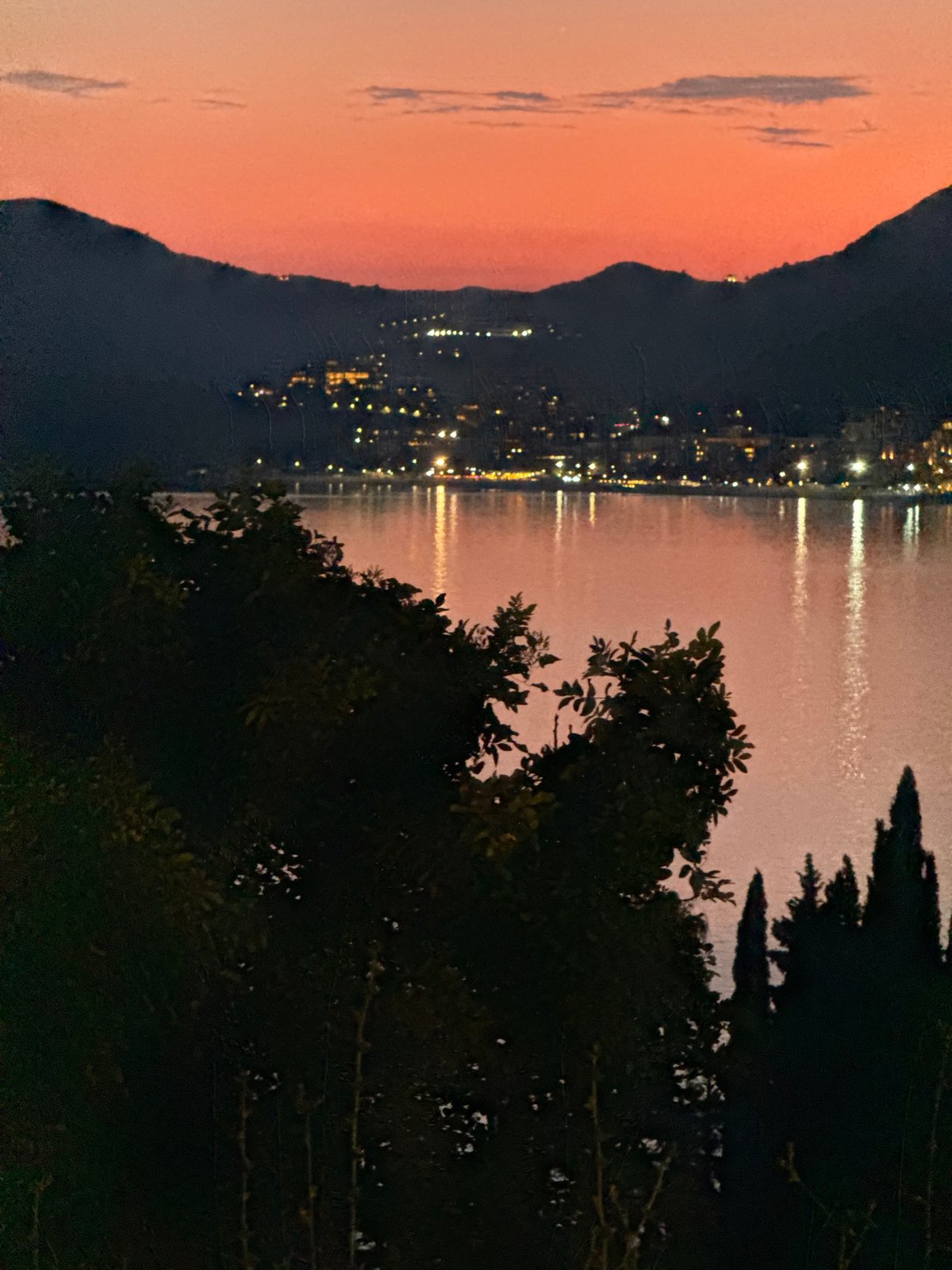Sunset over the Montenegro coast, mountains and city lights