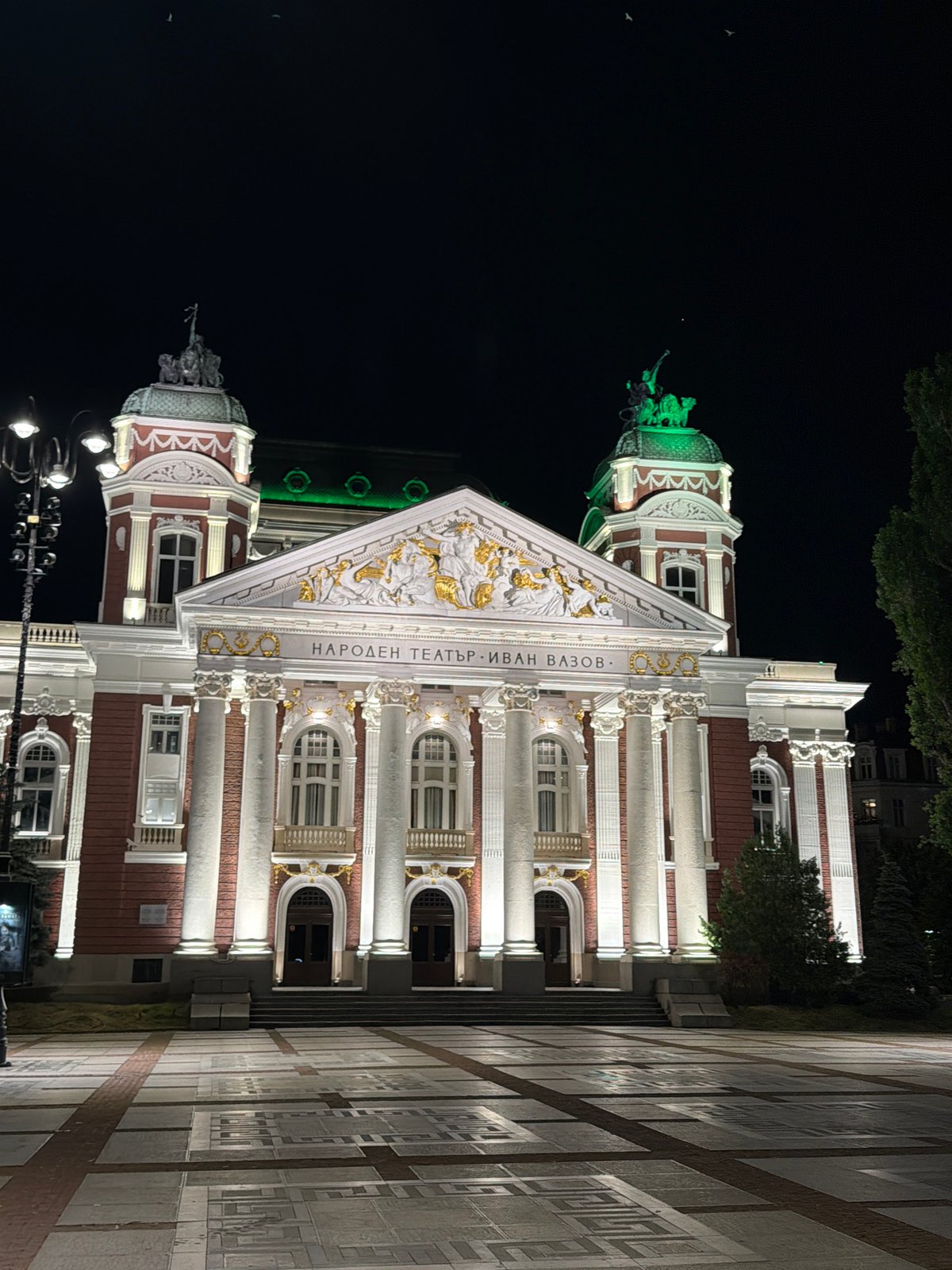 Sofia landmarks glow at night alongside an outdoor evening gathering