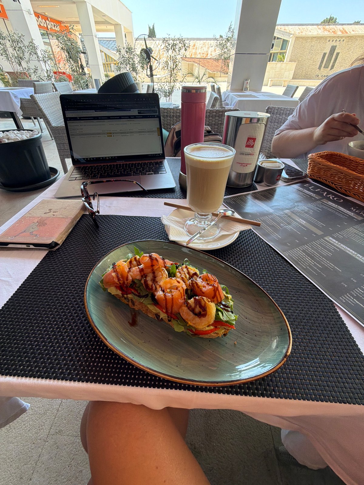 Working morning at a Budva café, streets and buildings nearby