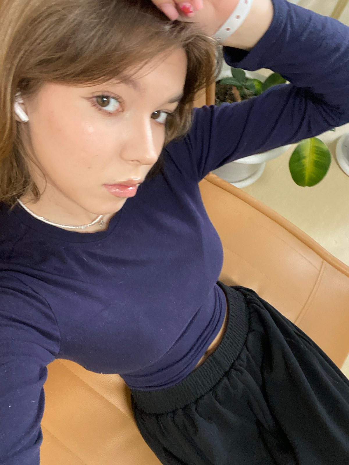 Woman relaxes on couch in plant-filled room in Perm